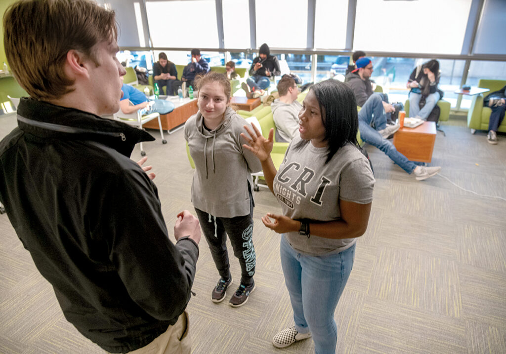 FINANCIALLY POSSIBLE: William Rider, executive vice president of student government at the Community College of Rhode Island, speaks with students Mari Megrdichian, center, and Davila Jackley. Jackley said without the Rhode Island Promise program, she would have had to take out loans and work more hours to afford tuition. / PBN PHOTO/MICHAEL SALERNO