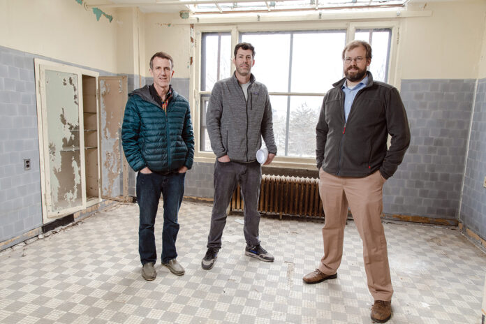 REBUILD READY: From left, Mark Van Noppen, CEO of RCG Armory LLC, architect Jack Ryan and Seth Zeren, principal of RCG Armory, stand in the room of a former nursing home at 31 Parade St. in Providence. Armory purchased the building a few years ago and will use Rebuild Rhode Island tax credits to turn it into 12 apartments. / PBN PHOTO/RUPERT WHITELEY REBUILD READY: From left, Mark Van Noppen, CEO of RCG Armory LLC, architect Jack Ryan and Seth Zeren, principal of RCG Armory, stand in the room of a former nursing home at 31 Parade St. in Providence. Armory purchased the building a few years ago and will use Rebuild Rhode Island tax credits to turn it into 12 apartments. / PBN PHOTO/RUPERT WHITELEY