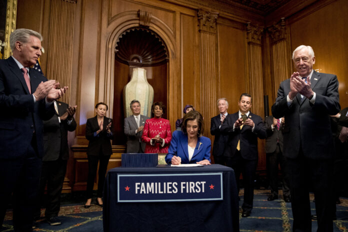 HOUSE SPEAKER Nancy Pelosi of Calif., accompanied by House Minority Leader Kevin McCarthy of Calif., left, House Majority Leader Steny Hoyer of Md., right, and other bipartisan legislators, signs the Coronavirus Aid, Relief, and Economic Security Act after it passed in the House on Capitol Hill, Friday, March 27, 2020, in Washington. The $2.2 trillion package will head to head to President Donald Trump for his signature. / AP FILE PHOTO/ANDREW HARNIK HOUSE SPEAKER Nancy Pelosi of Calif., accompanied by House Minority Leader Kevin McCarthy of Calif., left, House Majority Leader Steny Hoyer of Md., right, and other bipartisan legislators, signs the Coronavirus Aid, Relief, and Economic Security Act after it passed in the House on Capitol Hill, Friday, March 27, 2020, in Washington. The $2.2 trillion package will head to head to President Donald Trump for his signature. / AP FILE PHOTO/ANDREW HARNIK