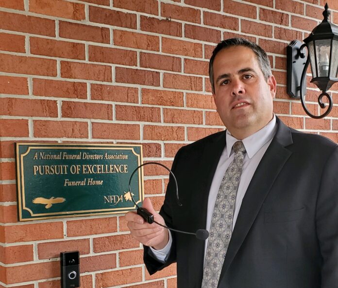 JEFFREY BERNARDO, funeral director at J.J. Duffy Funeral Home in Cumberland, holds a headset that is used to broadcast funeral services short distances over the radio in lieu of traditional services not being held during the COVID-19 pandemic. / COURTESY JEFFREY BERNARDO JEFFREY BERNARDO, funeral director at J.J. Duffy Funeral Home in Cumberland, holds a headset that is used to broadcast funeral services short distances over the radio in lieu of traditional services not being held during the COVID-19 pandemic. / COURTESY JEFFREY BERNARDO