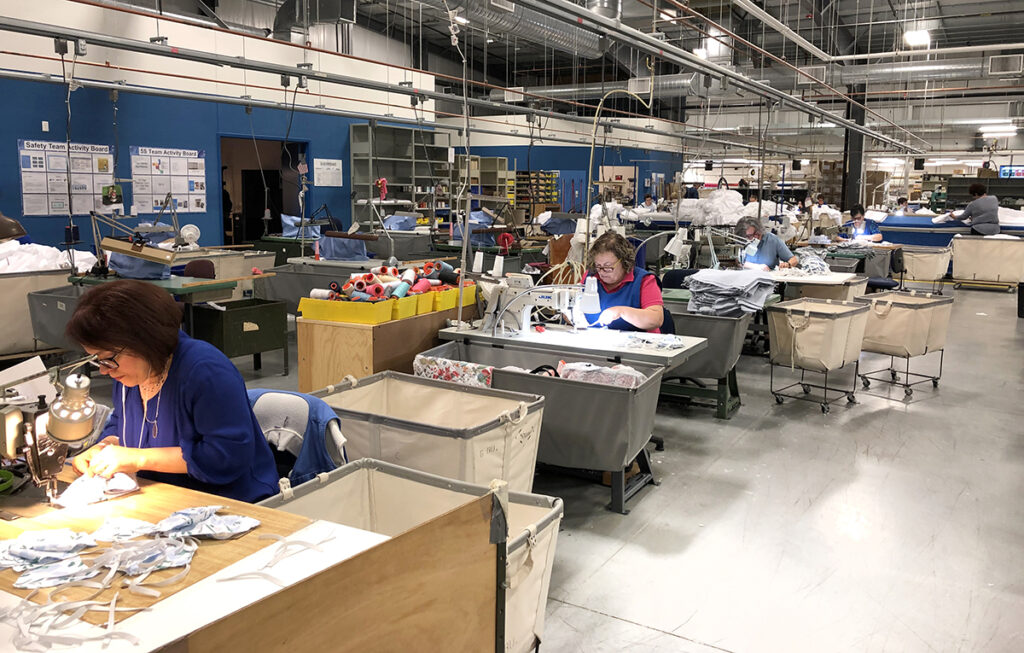 MASK MAKERS: Employees  at John Matouk & Co. stitch cloth personal protective equipment at the company’s Fall River facility. / COURTESY JOHN MATOUK & CO.
