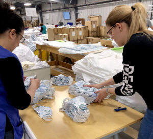 PROTECTIVE PRODUCT: Employees at linen manufacturer John Matouk & Co. in Fall River assemble cotton masks for health care workers that the company started making after it lost more than 30% of its revenue and had to lay off 20% of its workforce due to the COVID-19 pandemic. / COURTESY JOHN MATOUK & CO.