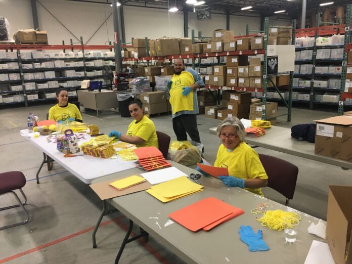 IVORY ELLA LLC employees, from left, Claritza Gonzales, Yasmin Ramos, Nelson Vasquez and Annette LaPietra, help build activity kits for national nonprofit Project Sunshine, which will be distributed to pediatric patients currently hospitalized. / COURTESY IVORY ELLA LLC IVORY ELLA LLC employees, from left, Claritza Gonzales, Yasmin Ramos, Nelson Vasquez and Annette LaPietra, help build activity kits for national nonprofit Project Sunshine, which will be distributed to pediatric patients currently hospitalized. / COURTESY IVORY ELLA LLC