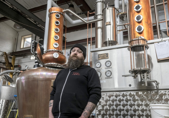 STILL PRODUCING: Dan Neff is a co-owner of The Industrious Spirit Co. in Providence. The distillery was prepared to open a tasting room for the public before the new coronavirus hit. Industrious Spirit is still selling its Structural Vodka through a walk-up window at the distillery. / PBN PHOTO/MICHAEL SALERNO STILL PRODUCING: Dan Neff is a co-owner of The Industrious Spirit Co. in Providence. The distillery was prepared to open a tasting room for the public before the new coronavirus hit. Industrious Spirit is still selling its Structural Vodka through a walk-up window at the distillery. / PBN PHOTO/MICHAEL SALERNO