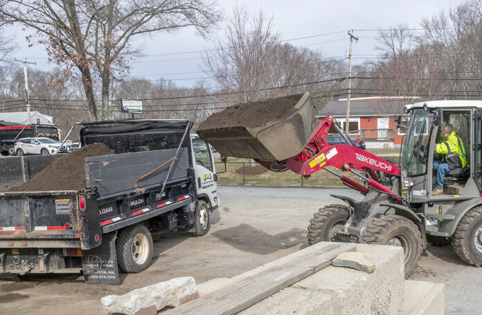 LOADING UP: Tommy Duell, driver/loader operator at J & L Landscaping Co. in Seekonk, transfers loam to the dump truck for delivery. The company continues to provide its services via delivery and curbside pickup during the coronavirus ­pandemic. / PBN PHOTO/MICHAEL SALERNO