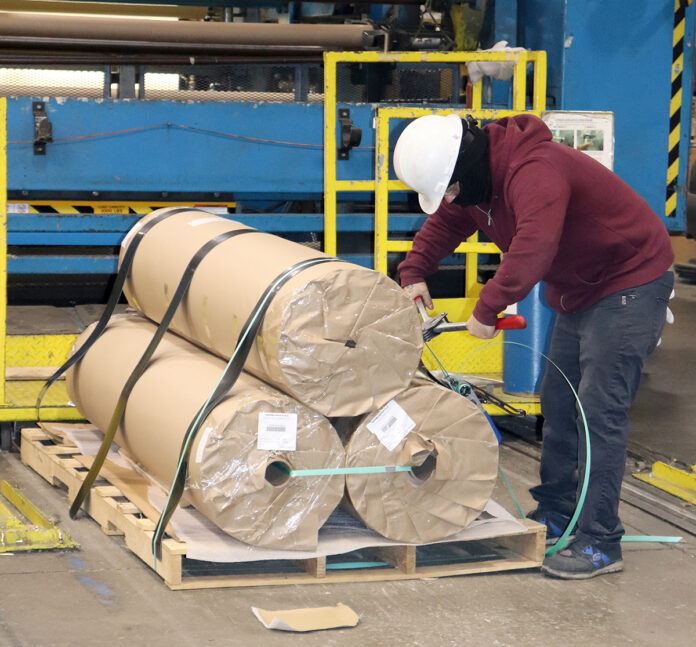 THAT’S A WRAP: Cooley Group employee Jonathan Rosado Morales packages finished product, an environmental protection barrier for the U.S. military. Despite a shortage of raw material, Cooley has maintained its shipping schedules. / COURTESY COOLEY GROUP THAT’S A WRAP: Cooley Group employee Jonathan Rosado Morales packages finished product, an environmental protection barrier for the U.S. military. Despite a shortage of raw material, Cooley has maintained its shipping schedules. / COURTESY COOLEY GROUP
