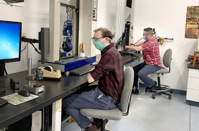 CROSS-TRAINED: Cooley research and development team members Peter Charpentier, left, and Art Menezes perform experiments on a new Cooley geomembrane technology. / COURTESY COOLEY GROUP CROSS-TRAINED: Cooley research and development team members Peter Charpentier, left, and Art Menezes perform experiments on a new Cooley geomembrane technology. / COURTESY COOLEY GROUP