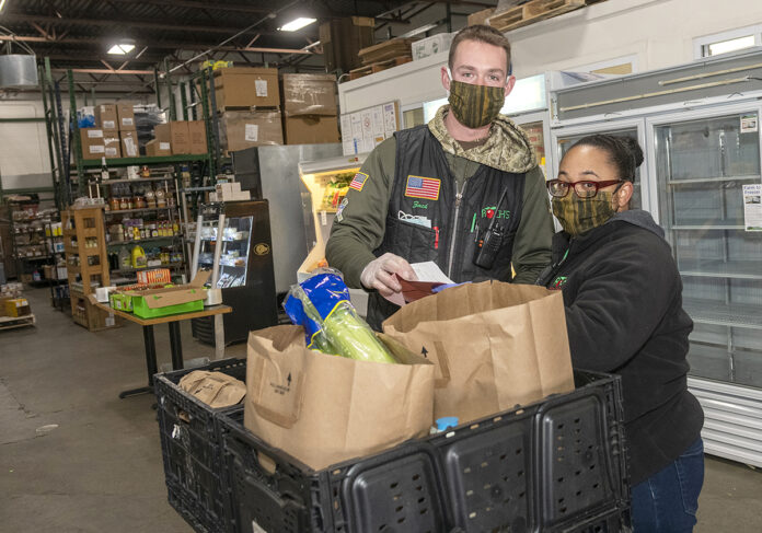 FOOD PREP: Roch’s Fresh Foods Vice President Zach Roch and Michelle Rivera, curbside pickup manager, prepare orders for delivery. The grocery wholesaler is now delivering food to people who are homebound because of COVID-19. / PBN PHOTO/MICHAEL SALERNO