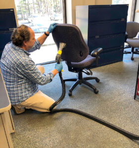 CHIEF EXECUTIVE CLEANER: Karl Wadensten, CEO and president of VIBCO Inc., steam-cleans an office chair, part of the daily process of keeping the coronavirus out of the Richmond factory. / COURTESY VIBCO INC.