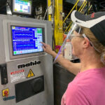PROPERLY SHIELDED: Terri Mehaffey operates an extrusion line at the Cooley Group factory in Pawtucket. Face shields and masks can be uncomfortable for those dealing with the heat on the factory floor. / COURTESY COOLEY GROUP