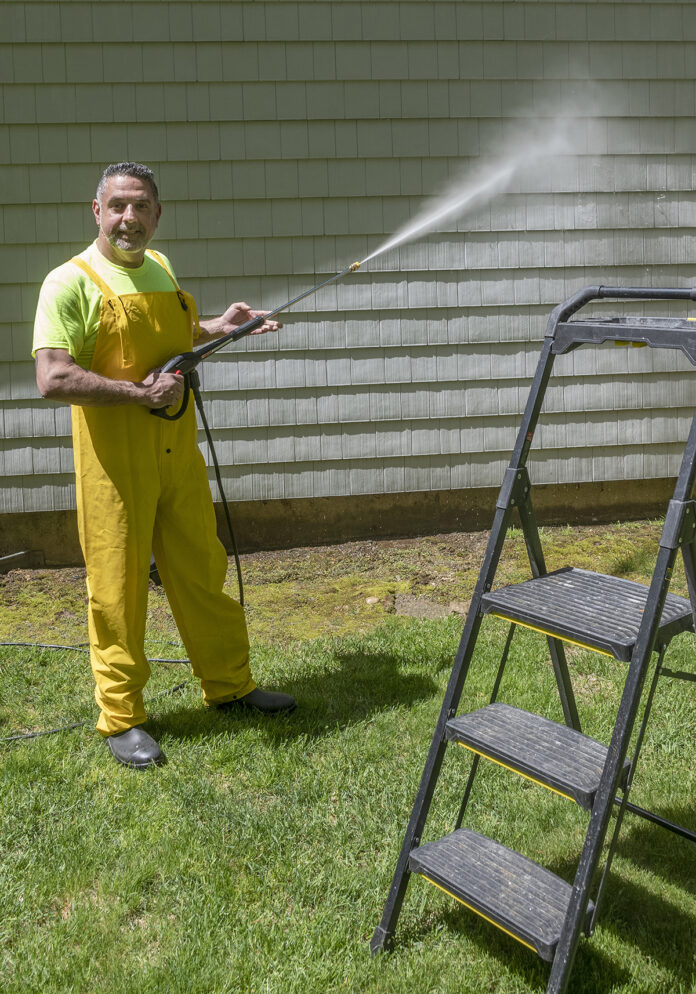 ONE-MAN GAME: David Rothenberg, owner of A Plus Handyman Services LLC, power-washes a house. The one-man operation offers a range of services, including painting, siding, excavating and sheet-rock installations. / PBN PHOTO/MICHAEL SALERNO