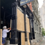 BOB BURKE, owner of Pot Au Feu in downtown Providence, covered his restaurant in plywood on Friday ahead of planned demonstrations. / PBN FILE PHOTO/NANCY LAVIN