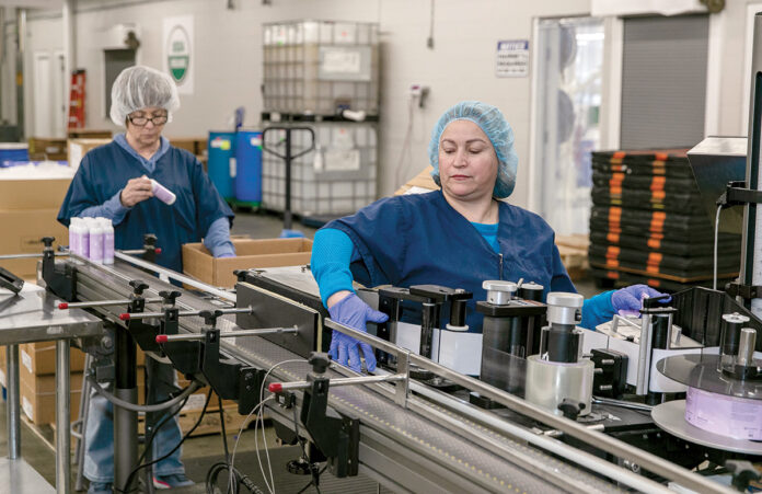 FEELING HEALTHY: Joann Stevens, left, and Angela Uricai help operate a machine at Pure Haven LLC. The Johnston-based company creates beauty products using toxin-free ingredients. / PBN PHOTO/TRACY JENKINS FEELING HEALTHY: Joann Stevens, left, and Angela Uricai help operate a machine at Pure Haven LLC. The Johnston-based company creates beauty products using toxin-free ingredients. / PBN PHOTO/TRACY JENKINS