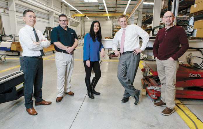 EVOLVING BUSINESS: From left, Yushin America Inc. President Takaya Sugimura, National Sales Manager Christopher Parillo, Human Resources Manager Karen Paolucci, Director of Operations Michael R. Greenhalgh and Inventory and Parts Sales Manager Brad Haworth are constantly evolving the company’s operations to better serve and strengthen relationships with its customers. / PBN PHOTO/RUPERT WHITELEY