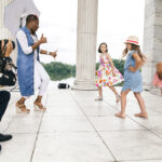 ON LOCATION: Donahue Models & Talent owner Yemi Sekoni directs, from left, Ruby Boesch, Molly McBride and Jazzy Rosa during a recent photo shoot at the Temple to Music in Roger Williams Park in Providence. The photographer is Yan La Mort. / PBN PHOTO/RUPERT WHITELEY