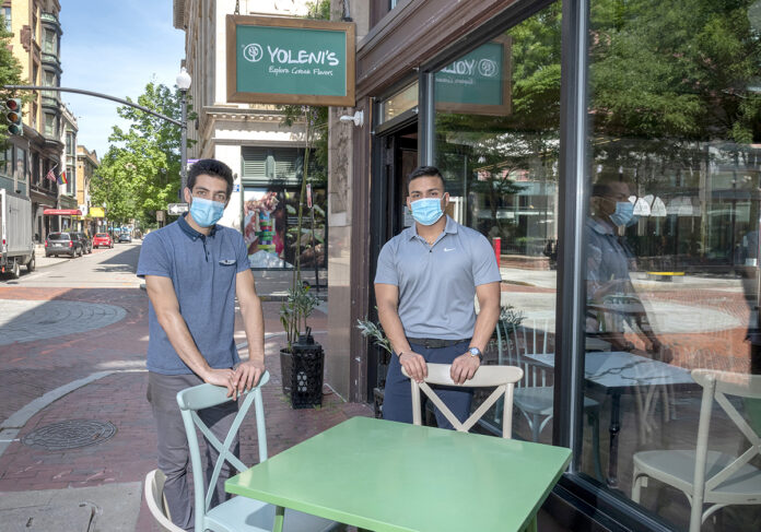 EMPTY SEATS: Yoleni’s co-owner John Philippides, left, and marketing manager Danny Willis say their business and many others in downtown Providence are dependent on college students returning to the city this month and next. / PBN FILE PHOTO/MICHAEL SALERNO EMPTY SEATS: Yoleni’s co-owner John Philippides, left, and marketing manager Danny Willis say their business and many others in downtown Providence are dependent on college students returning to the city this month and next. / PBN FILE PHOTO/MICHAEL SALERNO