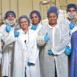 PREP WORK: Employees who work in Blount Fine Foods Corp.’s preparation room give a thumbs-up. COURTESY BLOUNT FINE FOODS CORP.