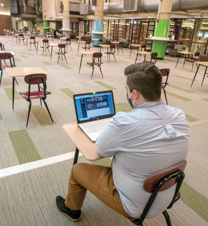 PLENTY OF ROOM: Tucker Quinn, a political science major from Warwick, studies alone at the Community College of Rhode Island in Warwick recently. Not many students are attending in-person classes in the fall semester. / PBN PHOTO/MICHAEL SALERNO PLENTY OF ROOM: Tucker Quinn, a political science major from Warwick, studies alone at the Community College of Rhode Island in Warwick recently. Not many students are attending in-person classes in the fall semester. / PBN PHOTO/MICHAEL SALERNO