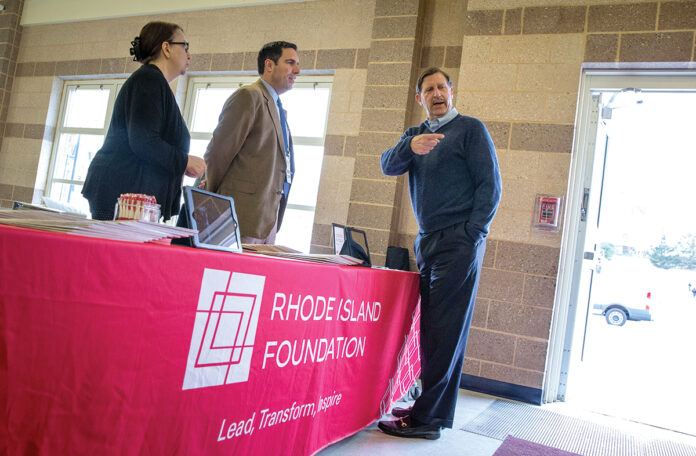 LEADING THE WAY: Rhode Island Foundation CEO and President Neil D. Steinberg, right, works with staffers at an expo event. COURTESY RHODE ISLAND FOUNDATION