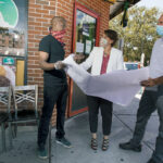 MAPPING IT OUT: From left, Ricky Bernard, co-owner of Island House Restaurant; Providence Revolving Fund Executive Director Carrie Zaslow; and Project Manager Thomas D’Ovidio go over a map outside of Bernard’s establishment.  / PBN PHOTO/RUPERT WHITELEY