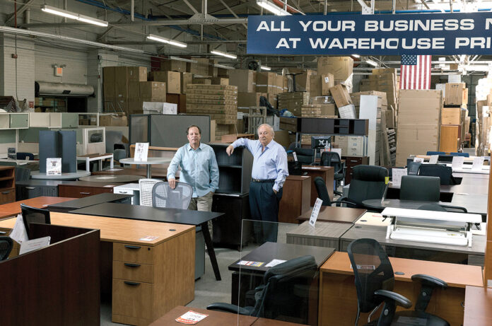 VALUED CUSTOMERS: Jon Weiss, left, vice president of National Office Furniture Inc., with owner Howard Weiss in the company’s showroom on Branch Avenue in Providence. Jon Weiss says customer service has been at the heart of the company since it was established by his grandfather in 1919. / PBN PHOTO/RUPERT WHITELEY VALUED CUSTOMERS: Jon Weiss, left, vice president of National Office Furniture Inc., with owner Howard Weiss in the company’s showroom on Branch Avenue in Providence. Jon Weiss says customer service has been at the heart of the company since it was established by his grandfather in 1919. / PBN PHOTO/RUPERT WHITELEY