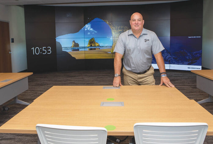 BIG SCREEN: Bob Mathews, account manager for CCS Presentation Systems New England, stands in front of a large 24-cube video wall within the engineering emerging technologies lab inside the new School of Engineering at Roger Williams University. / PBN PHOTO/KATE WHITNEY LUCEY