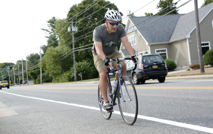 NOW YOU SEE HIM: Joe Loberti, president of Revolution Cycle Works Co. in Charlestown, goes for a bike ride along Boston Neck Road in Narragansett. Loberti is working on technology that will improve the ability of collision-prevention systems in new cars to detect cyclists.  / PBN PHOTO/ELIZABETH GRAHAM