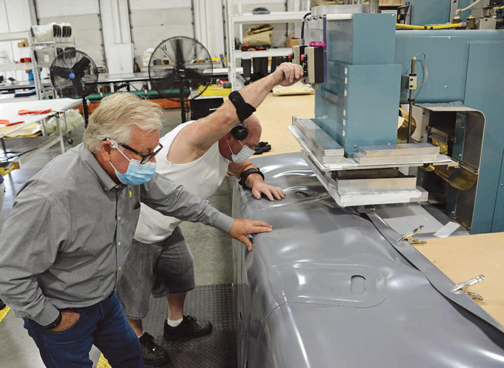 CHIEF INSPECTOR: Richard Fryburg, left, president of Subsalve USA, examines one of the company’s products as it’s being manufactured by employee Ray Stacy on the factory floor in North Kingstown. Subsalve is projecting growth in overseas sales heading into 2021. / PBN PHOTO/ELIZABETH GRAHAM