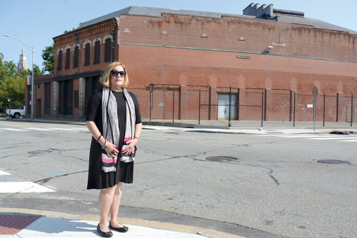 PARK CONCERNS: Sharon Steele, president of the Jewelry District Association, stands in front of the proposed site for the Dyer Street bus hub. She’s an opponent of the Providence Multi-Hub Bus System, in part because she believes that people waiting for buses at the Dyer Street hub would spill into the nearby waterfront park, diminishing the park’s intended use. / PBN PHOTO/ELIZABETH GRAHAM