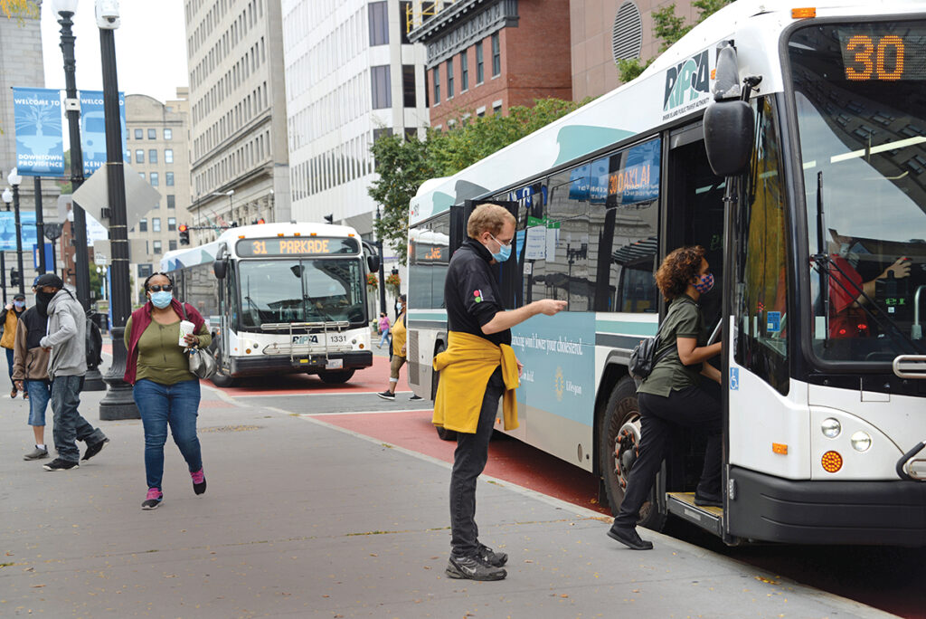 DIVIDED: Riders board a bus from the main hub at Kennedy Plaza in Providence. The R.I. Department of Transportation has devised a plan that would split up the main bus depot into three hubs, but it has drawn opposition. / PBN PHOTO/ ELIZABETH GRAHAM