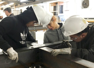 TEAMWORK: Robert Tolson, left, Lisa Silvio and Kyle Brown, right, line up beams to be bolted as part of the ironworking segment of Building Futures’ five-week pre-apprenticeship in 2019. Participants construct a 70-foot-by-14-foot project that contains many of the tools, materials and techniques used in building steel structures.   / COURTESY BUILDING FUTURES 