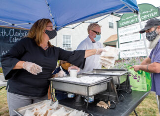 HUNGRY TO HELP: Heather Hole Strout, left, executive director of the Dr. Martin Luther King Jr. Community Center in Newport, distributes chowder and chicken vegetable bean soup to the needy recently in a new partnership with McGrath Clambakes Inc. of Newport. Assisting with the distribution are T.R. McGrath, third from left, owner of McGrath Clambakes, and his daughter Aibhlinn. / PBN PHOTO/KATE WHITNEY LUCEY