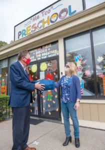 DELIVERY MAN: Lt. Gov. Daniel J. McKee meets with Kim Fortier, co-owner of Me Too Preschool in Woonsocket, as part of his effort to get businesses to apply for the Restore RI grant programs. He is also delivering face masks. / PBN PHOTO/MICHAEL SALERNO