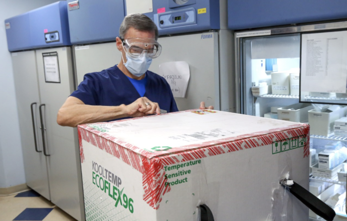 LIFESPAN CORP. Pharmacy Supervisor Richard Emery unpacks the first shipment of Moderna’s COVID-19 vaccine to arrive at Rhode Island Hospital on Dec. 22. / LIFESPAN CORP./BILL MURPHY