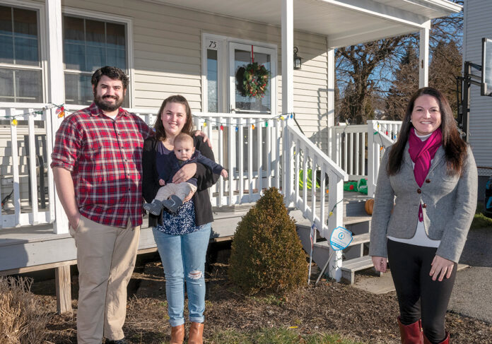 NEW HOME: Michael and Phoebe Koval, with their 4-month-old son, Barry, in front of their new home. The couple was renting a one-bedroom apartment in Providence before deciding to purchase a single-family property in the city’s North End. At right is their real estate agent, Shannon Buss, broker associate at Randall Realtors. PBN PHOTO/MICHAEL SALERNO NEW HOME: Michael and Phoebe Koval, with their 4-month-old son, Barry, in front of their new home. The couple was renting a one-bedroom apartment in Providence before deciding to purchase a single-family property in the city’s North End. At right is their real estate agent, Shannon Buss, broker associate at Randall Realtors. PBN PHOTO/MICHAEL SALERNO