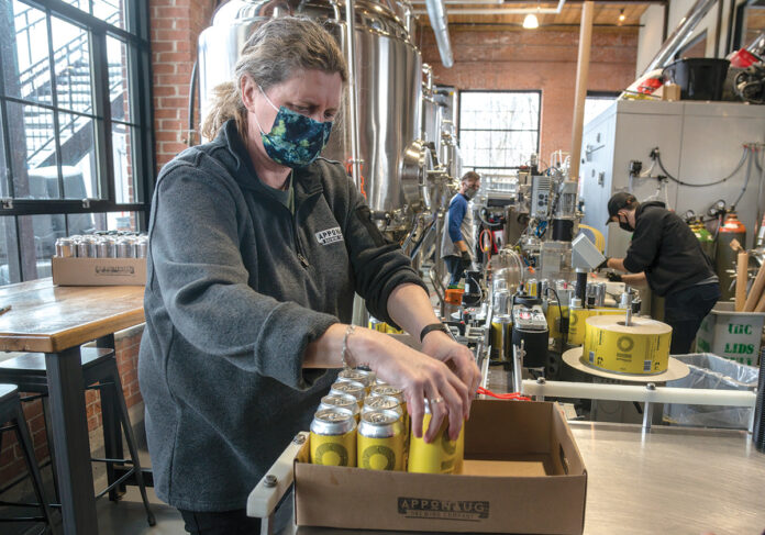 EYEING SPRING: Warwick’s ­Apponaug Brewing Co. is hoping spring will bring crowds back to a large outdoor patio. Above, foreground, is co-owner Kris Waugh. / PBN FILE PHOTO/MICHAEL SALERNO