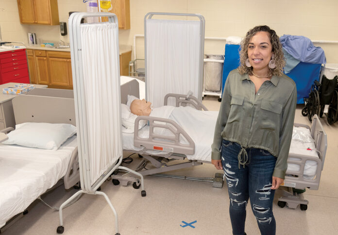 SIGNING UP: Kayla Amado, an occupational therapist, is one of the growing number of people applying to the Community College of Rhode Island nursing program. She is in the CCRI lab at the Warwick campus.  / PBN PHOTO/MICHAEL SALERNO