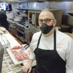 HUNGRY FOR HELP: Anthony Tarro, co-owner of Siena restaurant, says the business has struggled to find workers recently. In the background, sous chef Michael Lynch assists Tarro in the kitchen of Siena’s East Greenwich location. / PBN PHOTO/ELIZABETH GRAHAM