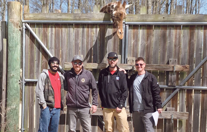 BONDING TIME: Employees from Connectivity Point Design & Installation LLC spend time with a giraffe while working at Roger Williams Park Zoo in Providence. / COURTESY CONNECTIVITY POINT DESIGN & INSTALLATION LLC BONDING TIME: Employees from Connectivity Point Design & Installation LLC spend time with a giraffe while working at Roger Williams Park Zoo in Providence. / COURTESY CONNECTIVITY POINT DESIGN & INSTALLATION LLC