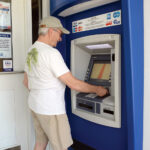 CASH FLOW: Russell Morrill of Westerly uses an ATM at The Washington Trust Co. branch in Westerly recently. Banks and credit unions are expecting to see a decline in the size of deposits as the COVID-19 crisis passes. / PBN PHOTO/ELIZABETH GRAHAM