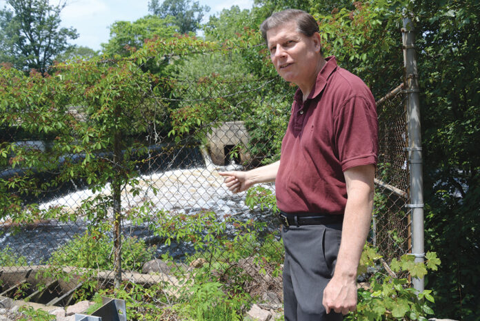 POINT OF CONTENTION: State Rep. Brian Patrick Kennedy overlooks the Potter Hill Dam at the Pawcatuck River. The town of Westerly wants to remove the dam, but some residents in Westerly and Hopkinton are concerned about the aftereffects. / PBN PHOTO/ELIZABETH GRAHAM