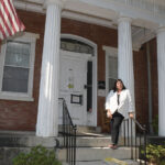 COVID CASUALTY: Stephanie lgoe stands in front of the former Hallworth House building in Providence, a nonprofit nursing home where she served as administrator before it closed in the summer of 2020 due to the COVID-19 pandemic. / PBN PHOTO/MIKE SKORSKI