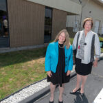 TRAINING HUB: Jennifer Menard, left, interim vice president of economic and business development at Bristol Community College, and Laura Douglas, college president, stand outside the future home of the school’s National Offshore Wind Institute on the New Bedford waterfront. / PBN PHOTO/MICHAEL SALERNO