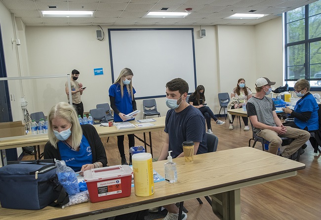 UNIVERSITY OF RHODE ISLAND students wait to be vaccinated for COVID-19 during a spring clinic in the school's Memorial Union on the Kingston campus in South Kingstown. / COURTESY UNIVERSITY OF RHODE ISLAND