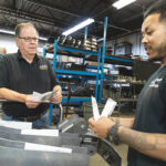 EXPANSION PLANS: Gerald Carlson, left, owner of Auto Rust Technicians in Cranston, recently spent $500,000 to expand operations and is considering buying more equipment. He’s pictured with manufacturing manager Karr Thang.  / PBN FILE PHOTO/RUPERT WHITELEY