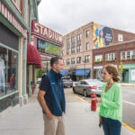 STILL STANDING: Downtowns across the state are hoping to fuel a post-pandemic rebound. Above, Woonsocket Mayor Lisa Baldelli-Hunt and Garrett Mancieri, director of the Downtown Woonsocket Collaborative, in Monument Square. / PBN FILE PHOTO/ MICHAEL SALERNO