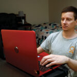 ON THE HUNT: Graham Berryman looks at his laptop at his apartment in Springfield, Mo. He is a lawyer who has struggled to find work during the pandemic after he was let go by his previous firm in August 2020. He has lived off savings. / AP PHOTO/BRUCE E. STIDHAM
