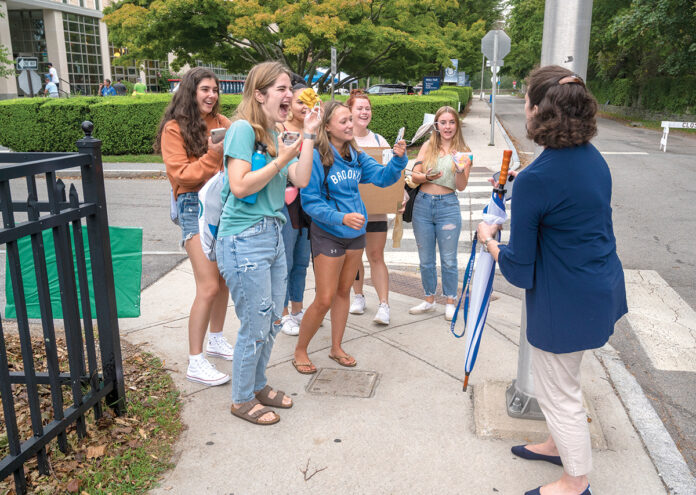 GREETING STUDENTS: Salve Regina University President Kelli J. Armstrong stops to talk with students as they return to campus recently in Newport. Armstrong says she enjoys getting to know students and soon after she arrived at the school in 2019, she implemented “Pizza with the President” gatherings, in which she would invite cohorts of students to her house for pizza. / PBN PHOTO/DAVE HANSEN