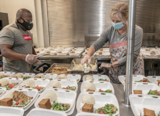 For many groups, hardships evolving, not subsiding DISHING OUT MEALS: Douglas Spikes, kitchen manager, and volunteer Kathy Block prepare meals for guests at social services nonprofit Amos House in Providence. / PBN PHOTO/MICHAEL SALERNO