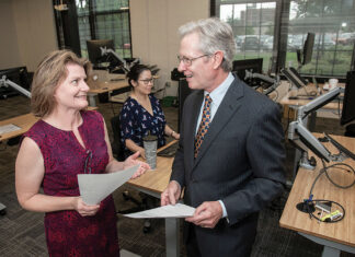 Making the sector more resilient COMMITTED TO COLLABORATION: Mary Johnson, left, program manager for Polaris MEP and the Rhode Island Textile Innovation Network, speaks with Michael Woody, president of Trans-Tex LLC and RITIN, in 2018. In the background is Tanya Dumrongmanee, Polaris program consultant. / PBN FILE PHOTO/MICHAEL SALERNO